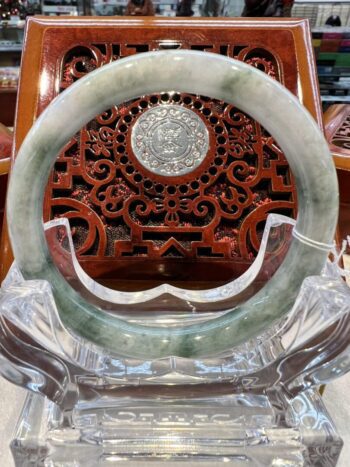 A large green jade bangle sitting on top of a table.