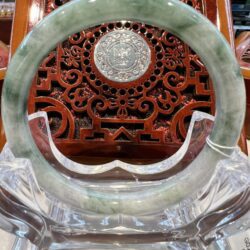 A circular green stone display with a wooden carving.