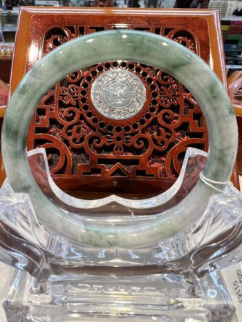 A circular green stone display with a wooden carving.