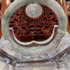 A large green jade ring sitting on top of a glass table.