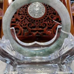 A circular stone carving on top of a clear glass stand.