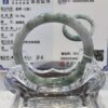 A glass display case with a green and white bracelet.