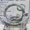 A green jade bangle is displayed in a glass case.