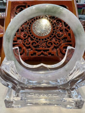 A large round glass plate with a carved wooden frame.