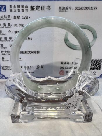 A clear glass sculpture with a circular design.