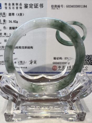 A glass plate with a green and white bracelet on it