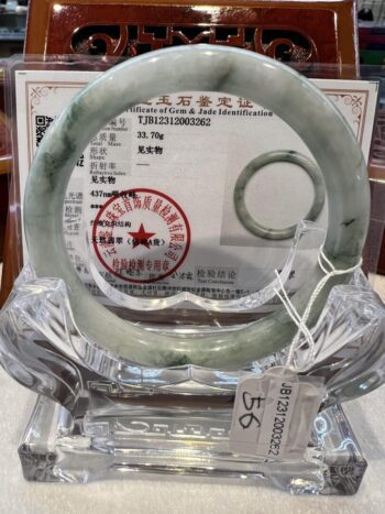 A green jade bangle is on display in an auction.