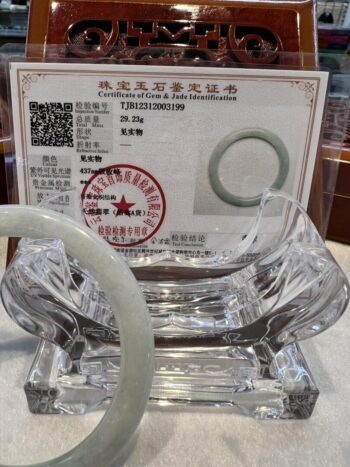 A glass bowl with a certificate and a pipe.