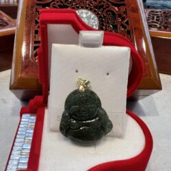 A green buddha statue sitting in a red box.