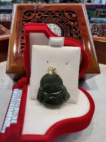 A green buddha statue sitting in a red box.