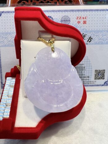 A white jade pendant sitting in a red box.