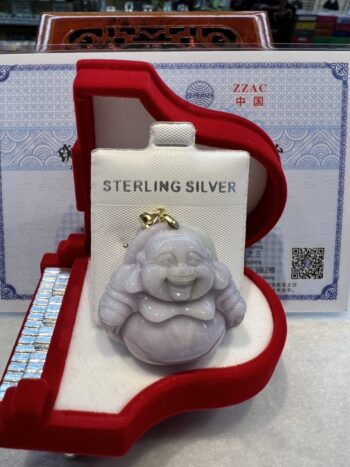 A silver buddha statue sitting in a red box.