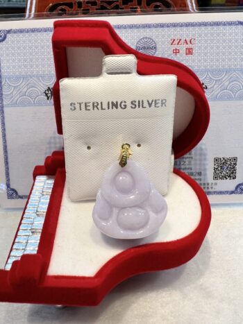 A white pendant sitting in the middle of a red box.