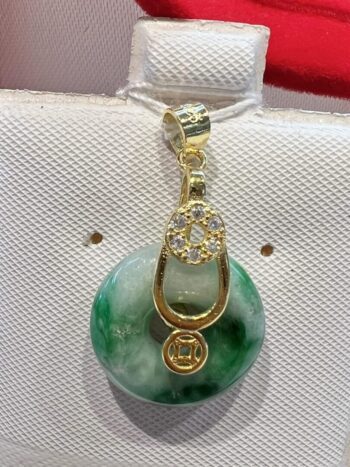 A green and white pendant on top of a purse.