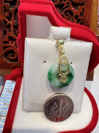 A green and white pendant sitting on top of a red box.