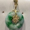 A green and white pendant with four leaf clover.