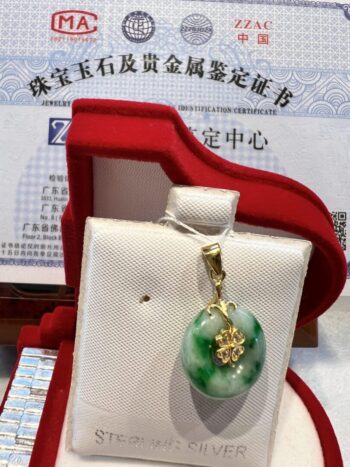 A green and white pendant sitting in a red box.