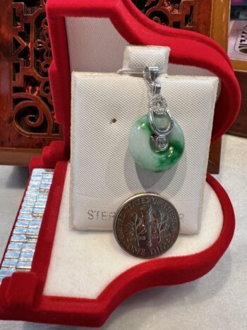 A green and white pendant sitting on top of a red box.