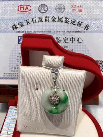 A green and white pendant sitting in a red box.