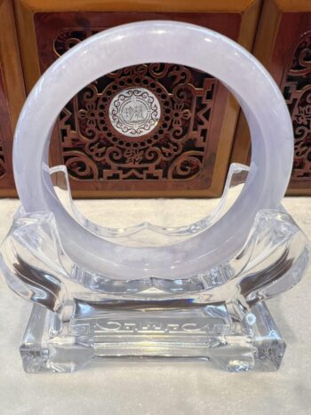 A clear glass sculpture with a circular design.