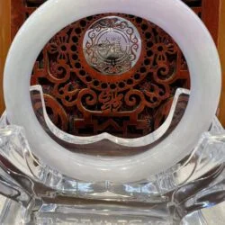 A white clock sitting on top of a glass table.