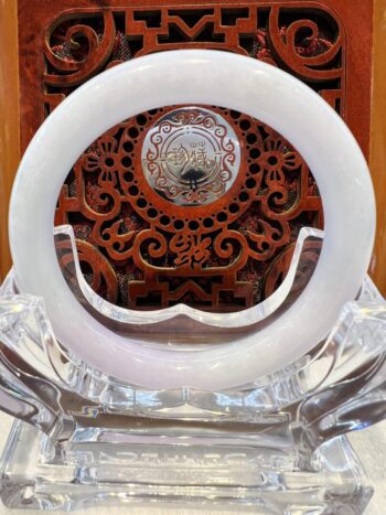 A white clock sitting on top of a clear glass table.