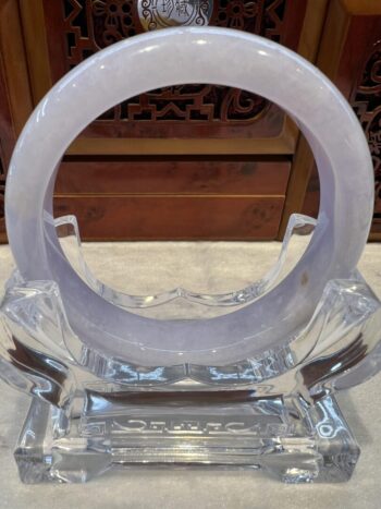 A clear glass sculpture with a circular design.