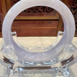 A clear glass sculpture with a white ring.