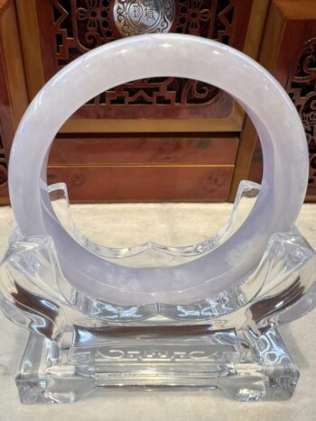 A clear glass sculpture with a white ring.