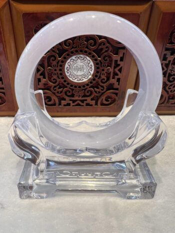 A clear glass sculpture with a circular design.