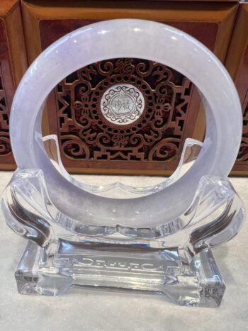 A clear glass sculpture with a circular design.