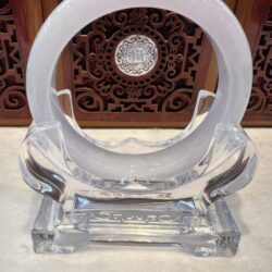 A clear glass sculpture with a circular design.