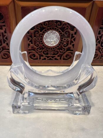 A clear glass sculpture with a circular design.