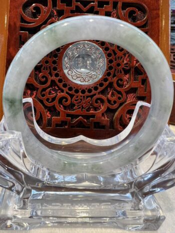 A round green and white marble plate with a silver coin on top.