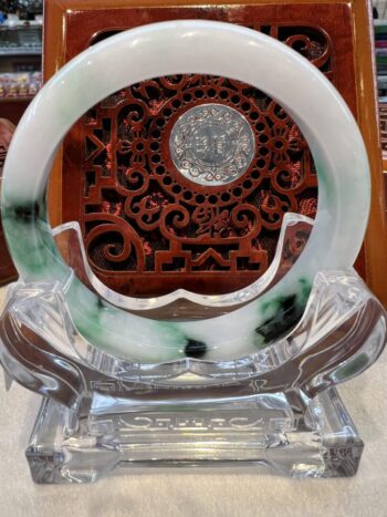 A green and white circular glass dish on display.