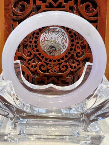 A white and red clock on top of a glass table.