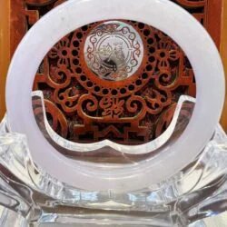 A white circular clock sitting on top of a wooden table.