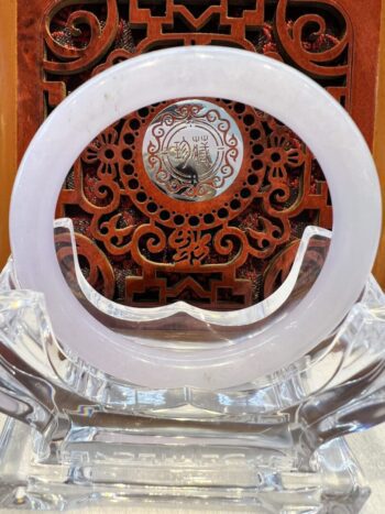 A white circular clock sitting on top of a wooden table.