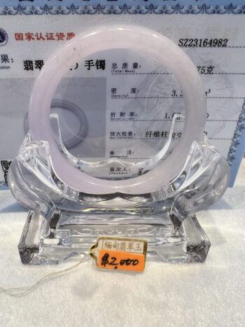 A clear plastic sculpture of an object with a sign on it.