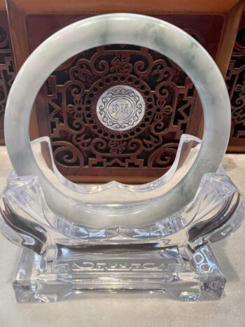 A clear glass sculpture with a circular design.