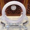A white ring sitting on top of a glass sculpture.
