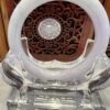 A clear glass sculpture with a white ring on top.