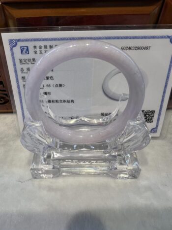 A white ring sitting on top of a clear glass holder.