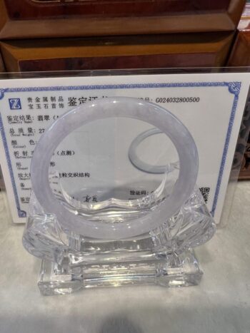 A clear plastic ring sitting on top of a certificate.