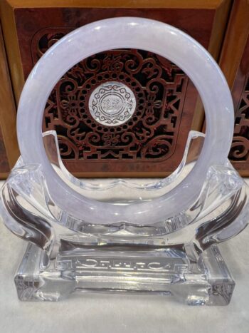 A clear glass sculpture with a circular design.