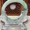 A green and white bracelet sitting on top of a glass table.