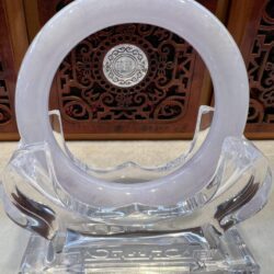 A clear plastic sculpture of an object with a circular design.