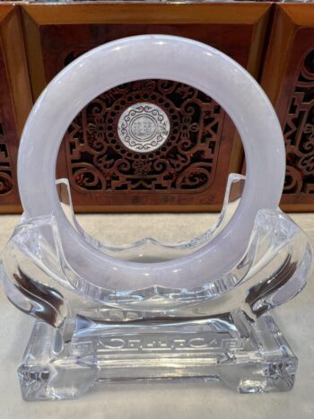 A clear plastic sculpture of an object with a circular design.