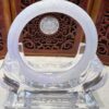 A white ring sitting on top of a clear glass object.