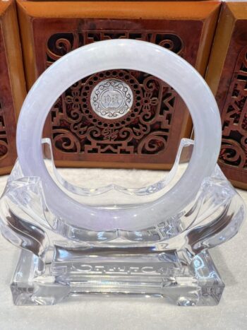 A white ring sitting on top of a clear glass object.